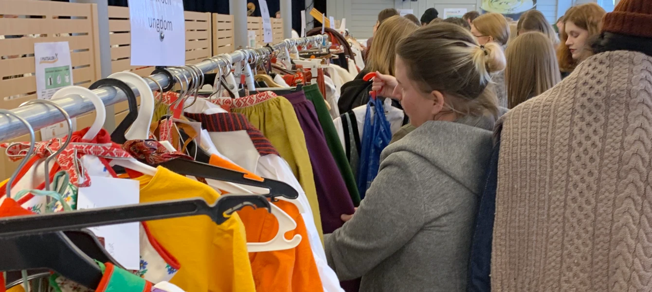 Människor tittar på folkdräkter på Folkdansringens folkdräktsmarknad